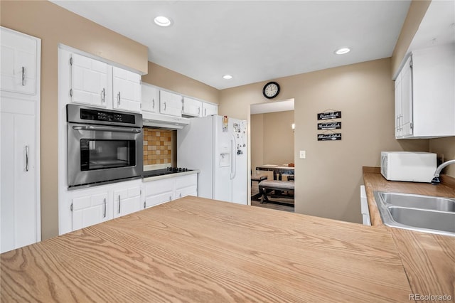 kitchen with white appliances, decorative backsplash, sink, and white cabinets