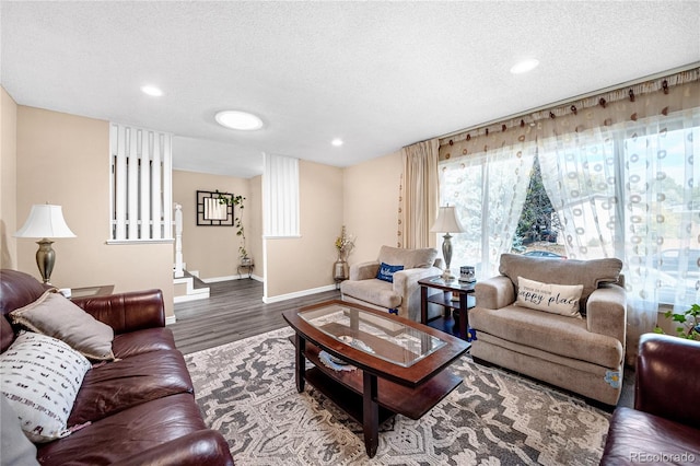 living room with a textured ceiling and dark wood-type flooring