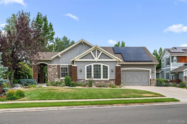 craftsman-style house featuring a front yard, a garage, and solar panels