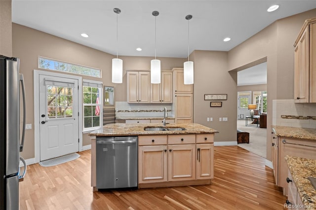 kitchen with appliances with stainless steel finishes, sink, light brown cabinets, backsplash, and light carpet