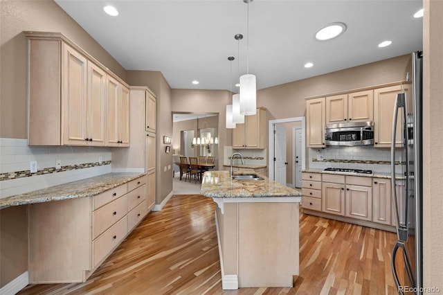 kitchen with stainless steel appliances, light hardwood / wood-style floors, light brown cabinetry, and sink