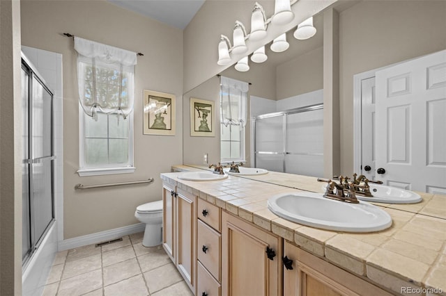 full bathroom with tile patterned flooring, bath / shower combo with glass door, toilet, and double sink vanity