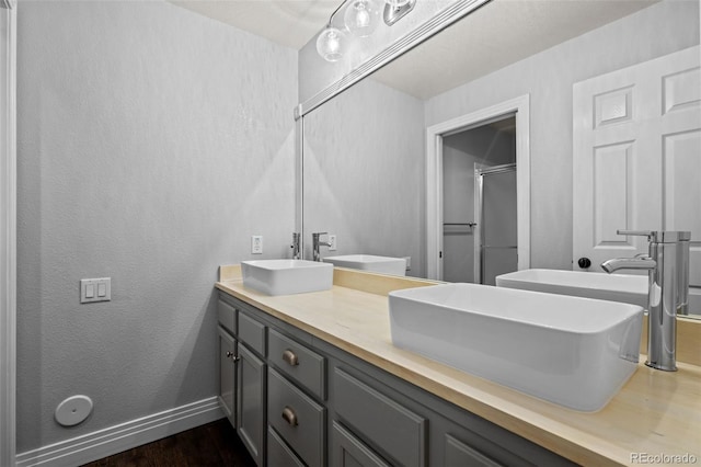 bathroom featuring hardwood / wood-style flooring and dual bowl vanity