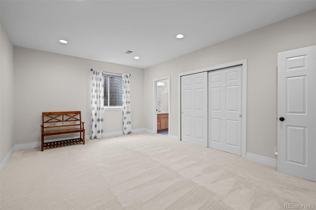 bedroom with connected bathroom and light colored carpet