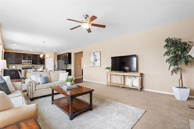 living room with light carpet and ceiling fan with notable chandelier