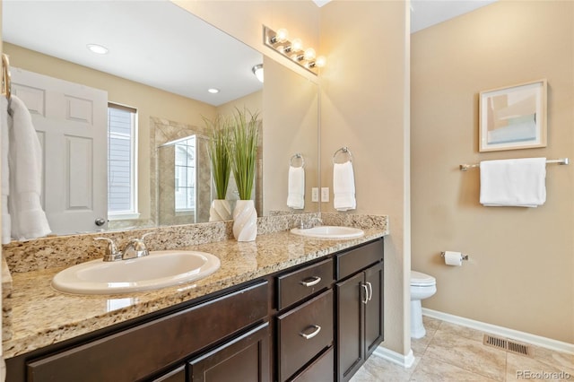 bathroom with tile patterned floors, vanity, toilet, and a shower with shower door