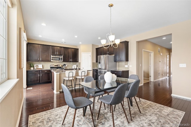 dining area with dark hardwood / wood-style floors and a chandelier