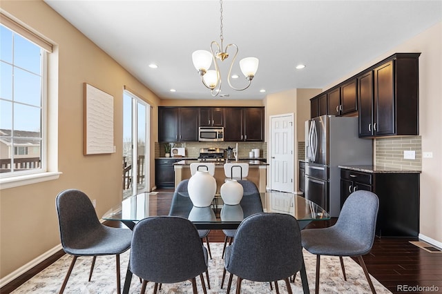 dining space with hardwood / wood-style floors and a notable chandelier