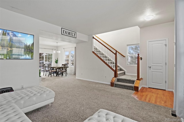 living room with carpet flooring and a notable chandelier