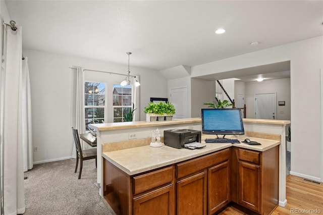 kitchen with a chandelier, light carpet, a center island, and hanging light fixtures