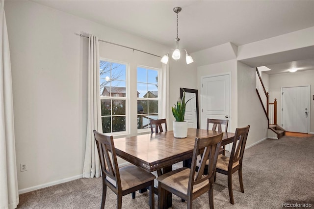 dining room featuring carpet flooring and a chandelier