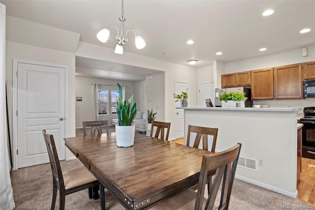 dining room with light carpet and an inviting chandelier