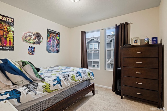 bedroom with a textured ceiling and light carpet