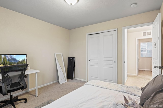 carpeted bedroom with a textured ceiling and a closet