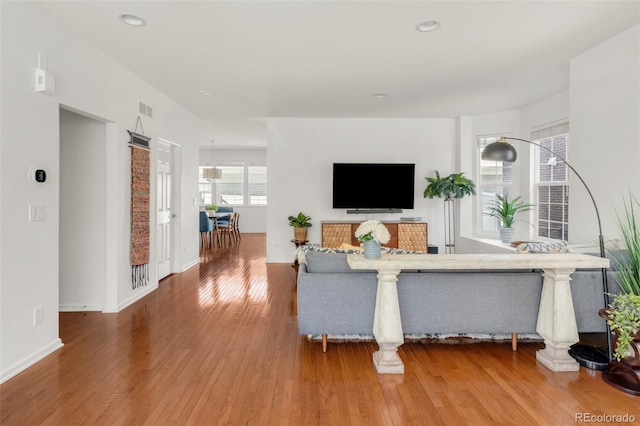 living area featuring recessed lighting, wood finished floors, visible vents, and baseboards