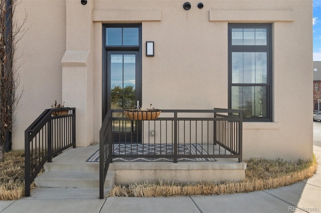 doorway to property featuring stucco siding