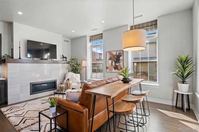 living room featuring recessed lighting, visible vents, baseboards, and wood finished floors