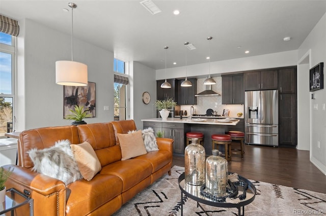 living room with recessed lighting, dark wood-style floors, visible vents, and a wealth of natural light