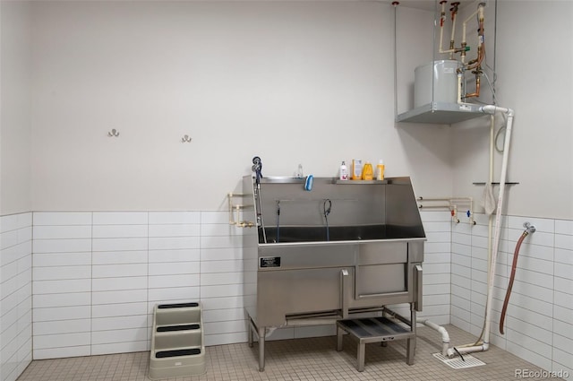 misc room featuring tile patterned flooring, tile walls, and wainscoting