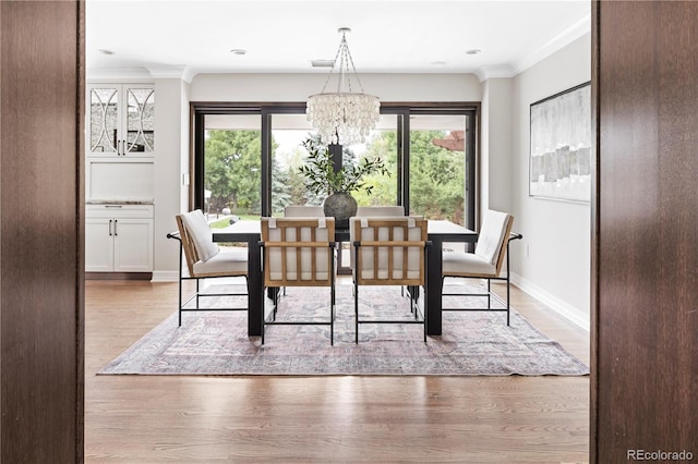 dining room featuring ornamental molding, a chandelier, and light wood-type flooring