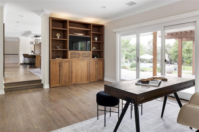 dining room with crown molding and light wood-type flooring