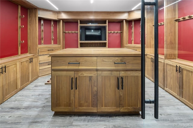 bar with wooden counters and light wood-type flooring