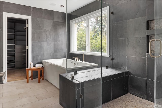 bathroom with separate shower and tub and tile walls