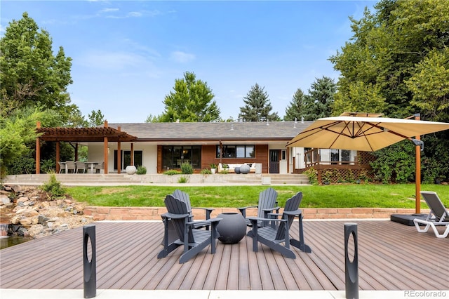 wooden deck with a pergola, a yard, a patio, and an outdoor fire pit