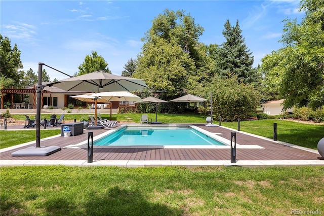 view of swimming pool featuring a yard and a deck