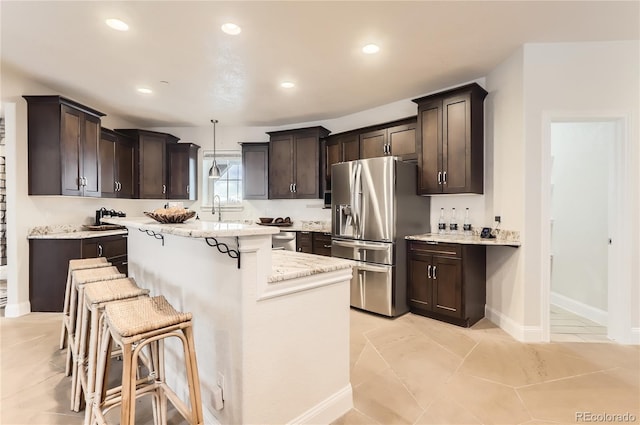 15280 Bannock St, Broomfield, CO 80023 - kitchen featuring stainless steel refrigerator with ice dispenser, a center island, dark brown cabinetry, a kitchen bar, and recessed lighting