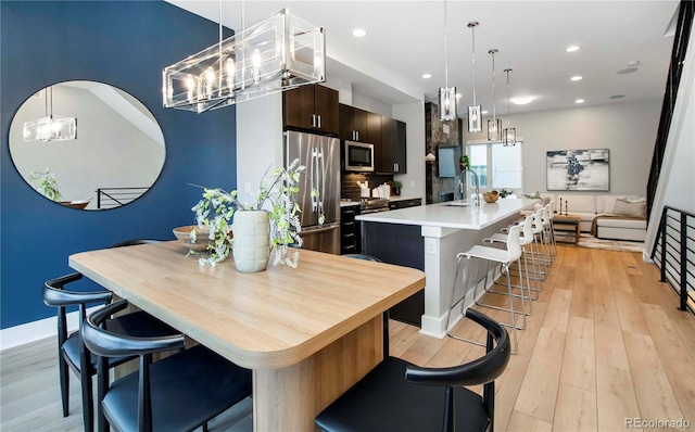 1933 Grove St, Denver, CO 80204 - dining area featuring recessed lighting, baseboards, an inviting chandelier, and light wood-style flooring