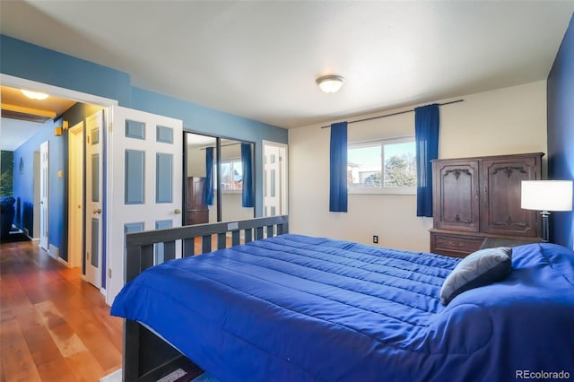 bedroom with dark wood-type flooring and a closet