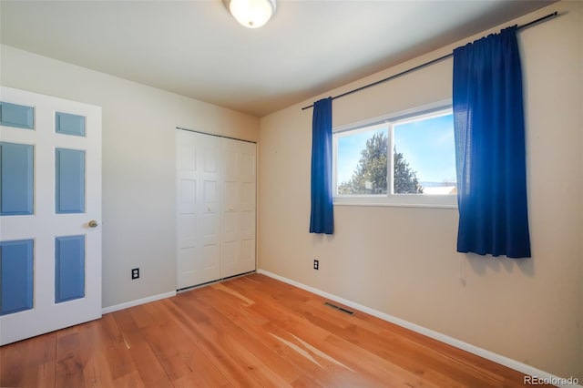 unfurnished bedroom featuring a closet and hardwood / wood-style flooring