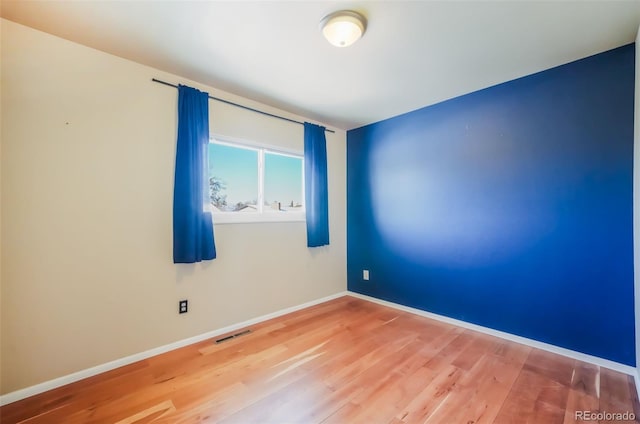 spare room featuring wood-type flooring