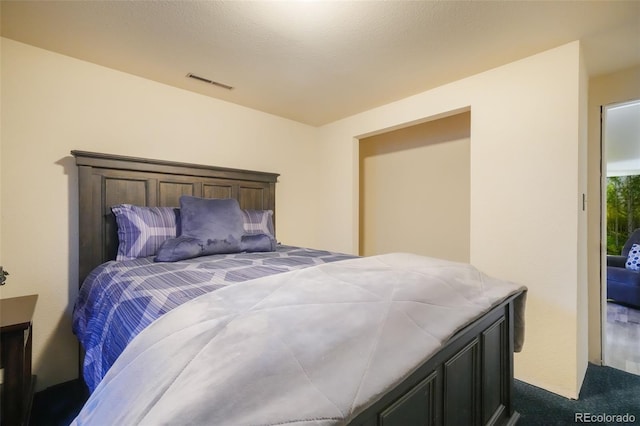 bedroom featuring carpet and a textured ceiling