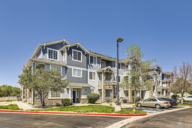 5255 Memphis St Unit 311, Denver, CO 80239 - view of front of home with uncovered parking and stone siding