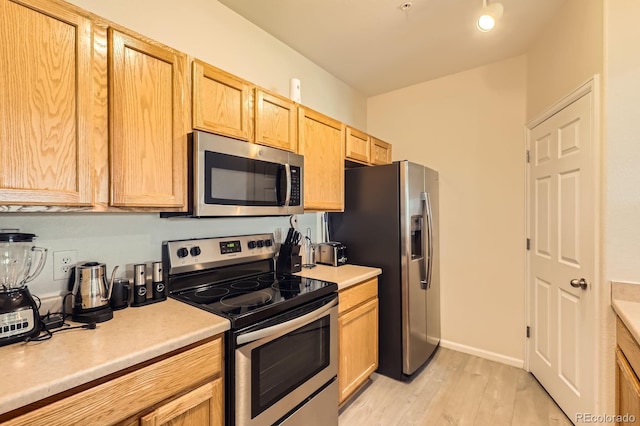 5255 Memphis St Unit 311, Denver, CO 80239 - kitchen featuring stainless steel appliances, light brown cabinetry, light wood-type flooring, and light countertops