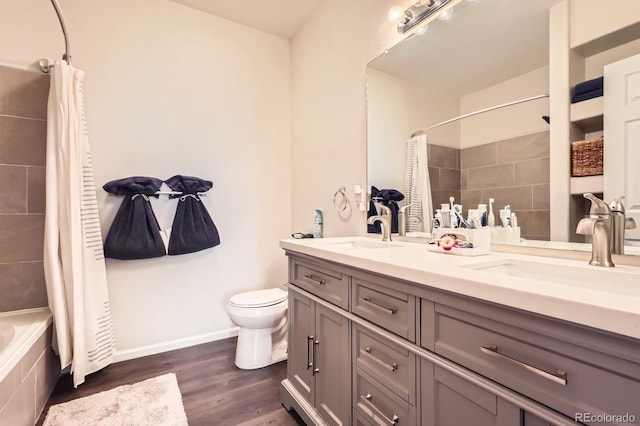 5255 Memphis St Unit 311, Denver, CO 80239 - bathroom with toilet, wood finished floors, double vanity, tiled shower / bath combo, and baseboards