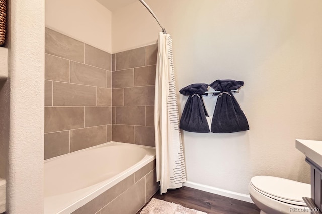 5255 Memphis St Unit 311, Denver, CO 80239 - full bathroom with baseboards, toilet, vanity, wood finished floors, and tiled shower / bath