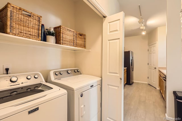 5255 Memphis St Unit 311, Denver, CO 80239 - washroom with washing machine and dryer, light wood finished floors, and rail lighting