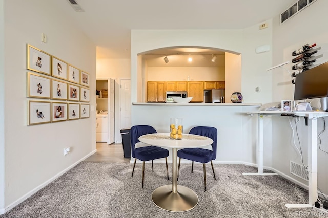 5255 Memphis St Unit 311, Denver, CO 80239 - dining space featuring arched walkways, carpet, washer / dryer, and baseboards