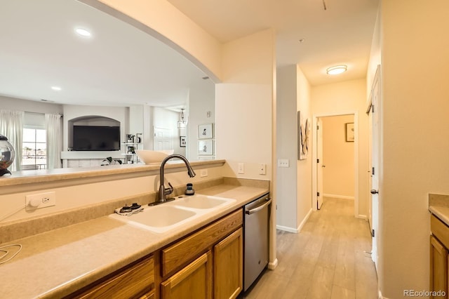 5255 Memphis St Unit 311, Denver, CO 80239 - kitchen with a sink, dishwasher, brown cabinets, light wood finished floors, and arched walkways