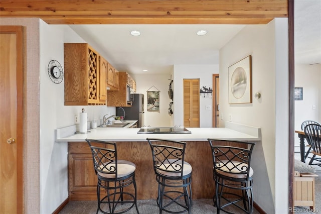 kitchen with a sink, stainless steel appliances, light countertops, baseboards, and recessed lighting