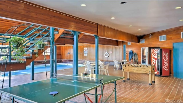 recreation room with wooden walls and recessed lighting