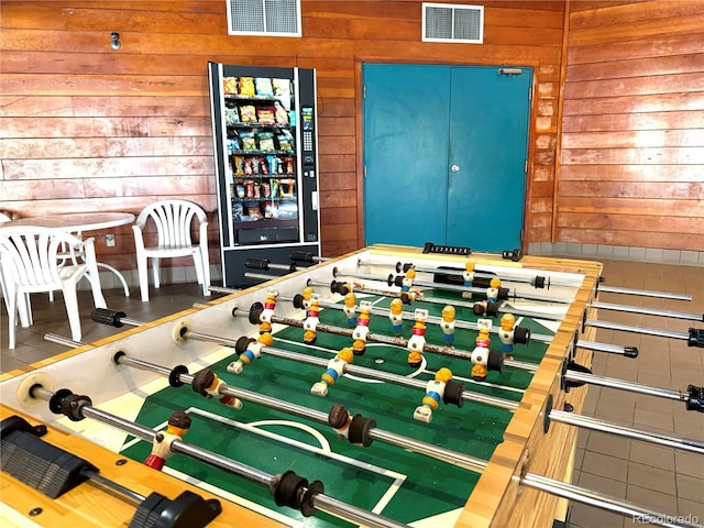 game room featuring wood walls