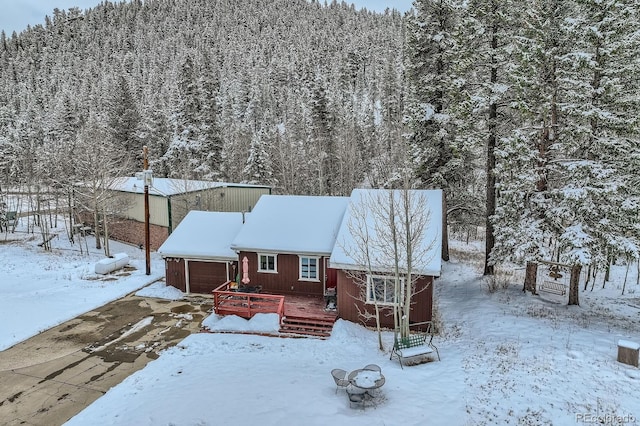 1350 Tolland Rd, Rollinsville, CO 80474 - snow covered property featuring a garage, a wooden deck, and a wooded view