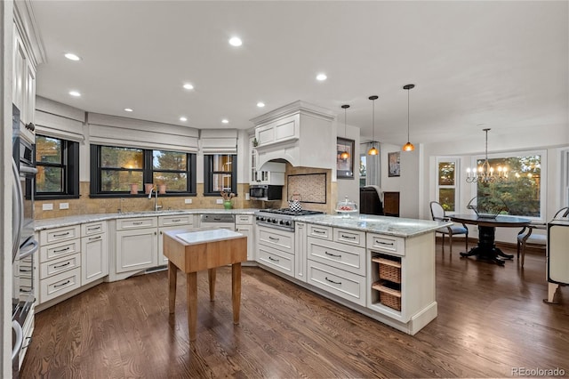 kitchen featuring backsplash, dark wood-type flooring, white cabinets, hanging light fixtures, and stainless steel gas cooktop