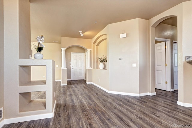 interior space with ornate columns and dark wood-type flooring