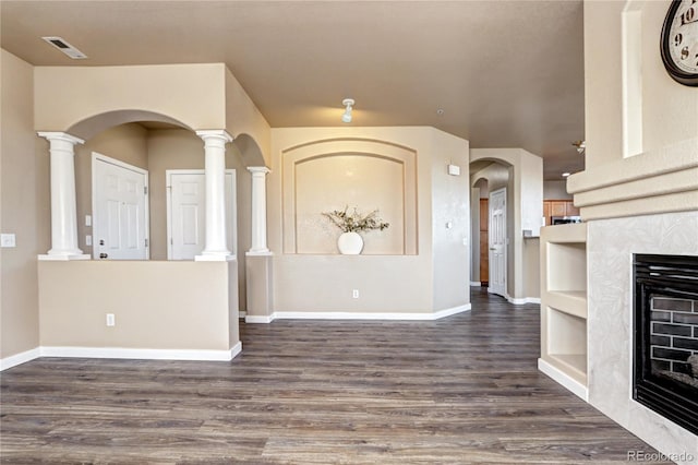 interior space with dark wood-type flooring and ornate columns