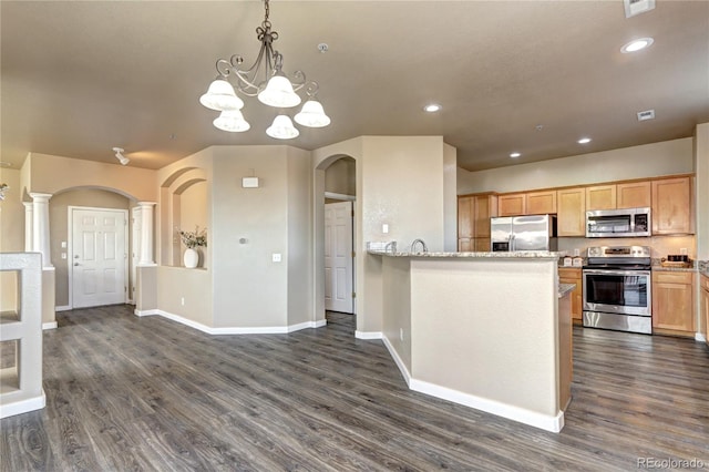 kitchen featuring pendant lighting, appliances with stainless steel finishes, light stone counters, dark hardwood / wood-style flooring, and light brown cabinets